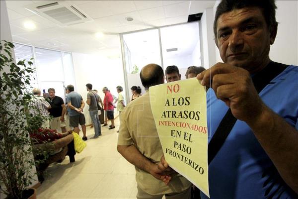 Una persona muestra un cartel de protesta al comienzo de la Mesa de Gibraltar. EFE