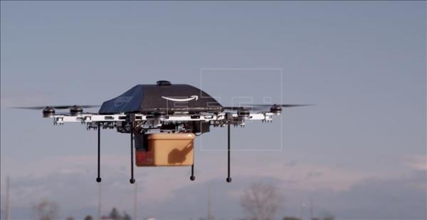 En la imagen un "dron" de la compañía Amazon llevando el paquete de hasta 2,3 kilogramos en una caja de color naranja. Foto cedida .